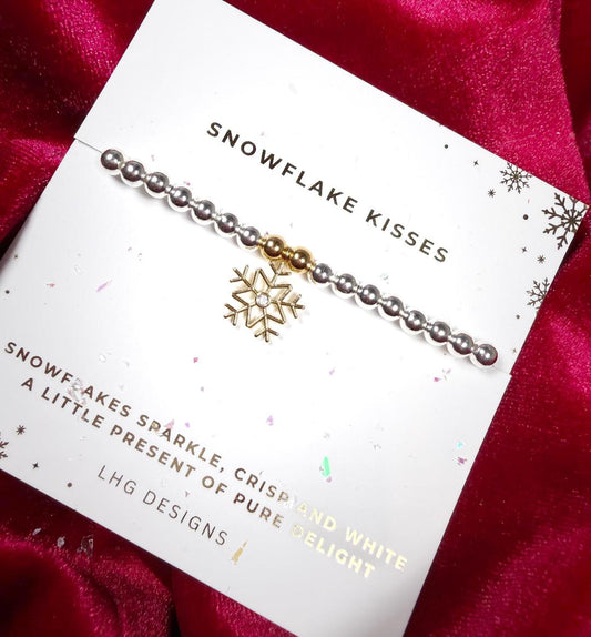 Bracelet with snowflake charm on a branded card against a red fabric background